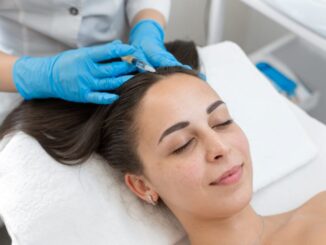 Eine Frau liegt auf einer Behandlungsliege, während eine medizinische Fachkraft mit Handschuhen eine Injektion in die Kopfhaut setzt